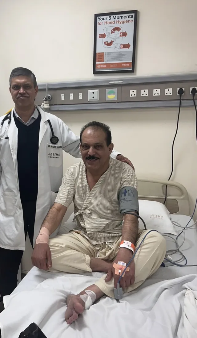 مريض مبتسم على سرير المستشفى مع طبيبه في Artemis Hospitals بالهند